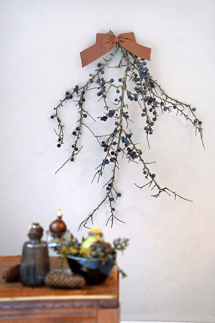 Wall decoration with berry twigs and bow