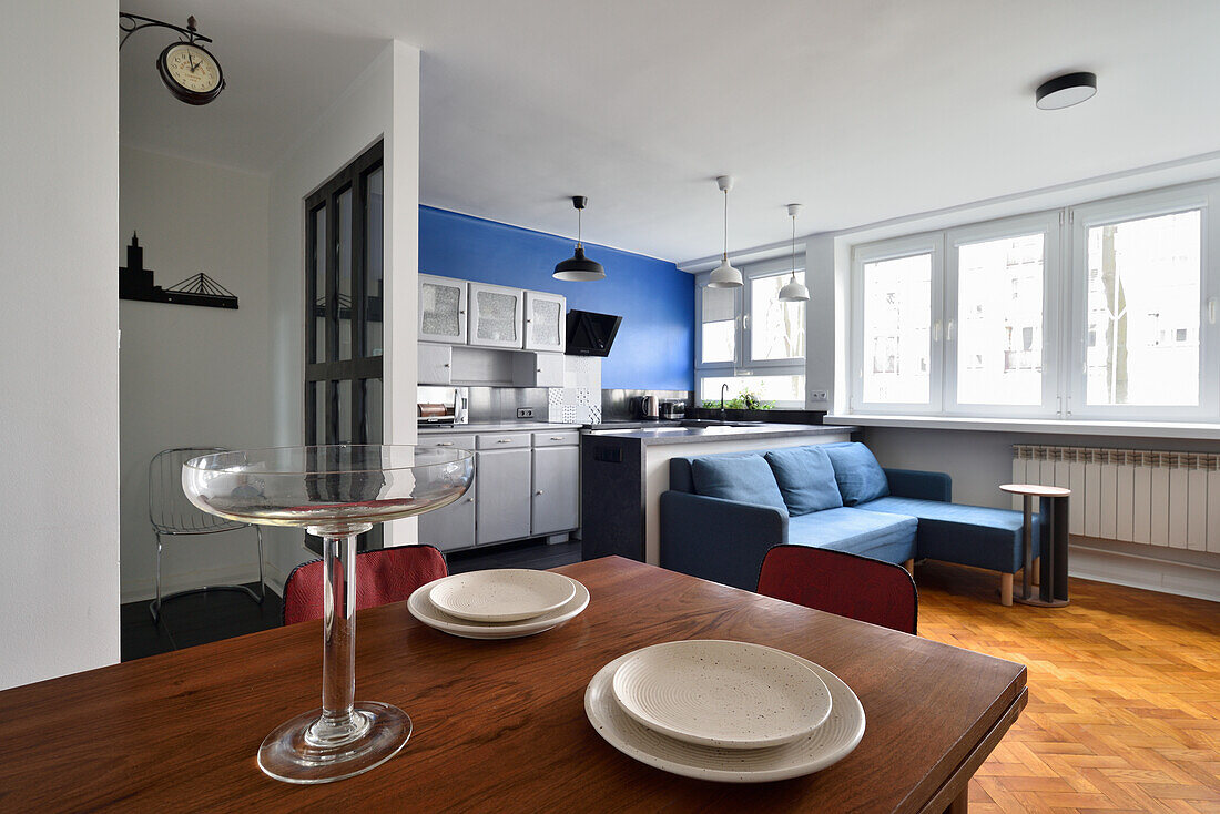 Küchenbereich mit blauer Akzentwand und angrenzendem Essbereich