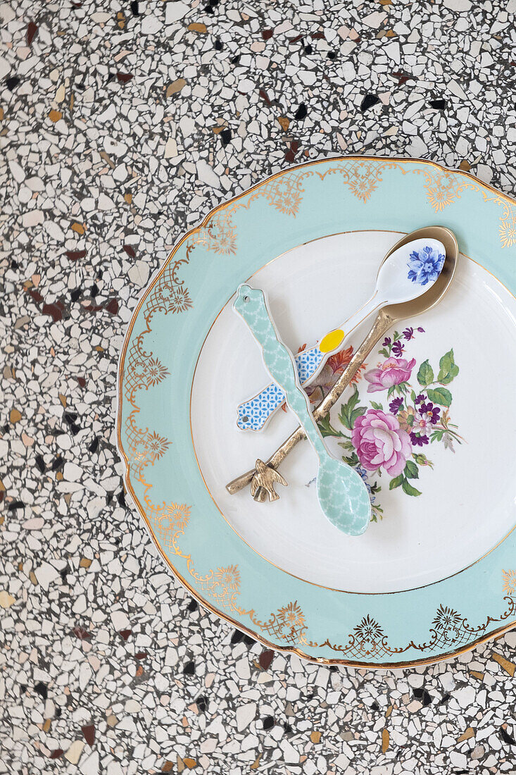 Floral plate on terrazzo table with patterned cutlery