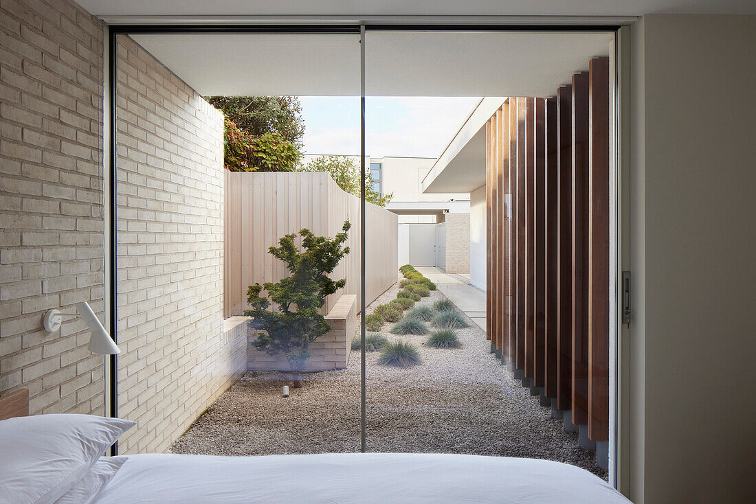 View of the minimalist courtyard garden with gravel path from the bedroom