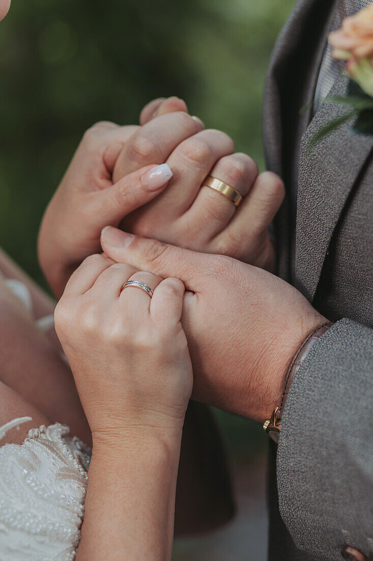 Hands of a bride and groom with wedding rings