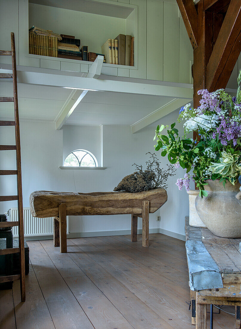 Room with wooden bench, ladder and bookshelf