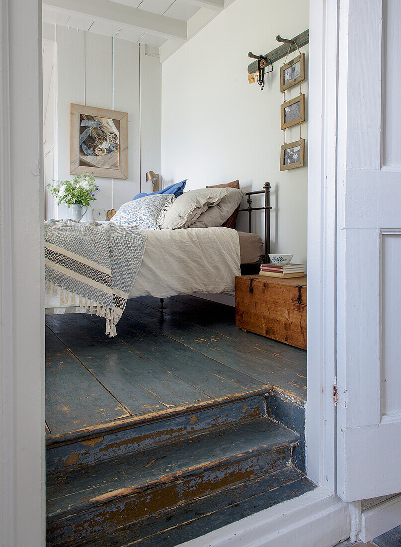 Bedroom with wooden floor, metal bed and vintage decor