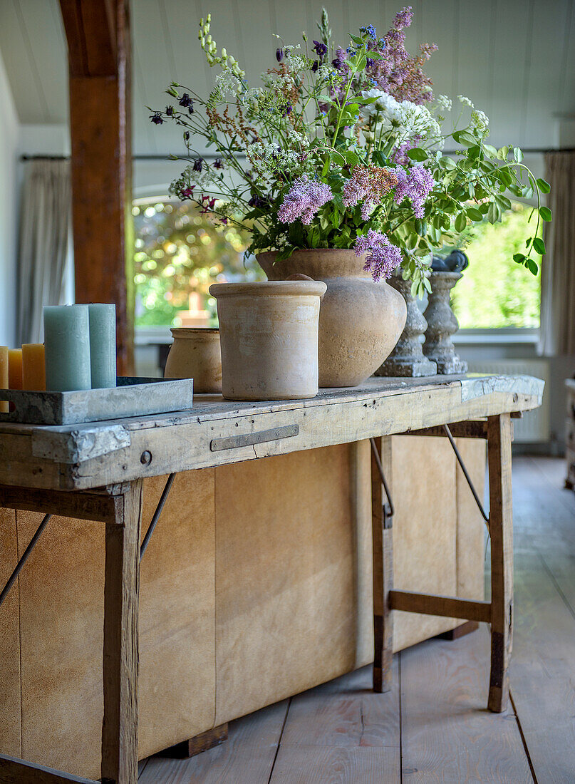 Rustikaler Holztisch mit üppigem Blumenarrangement