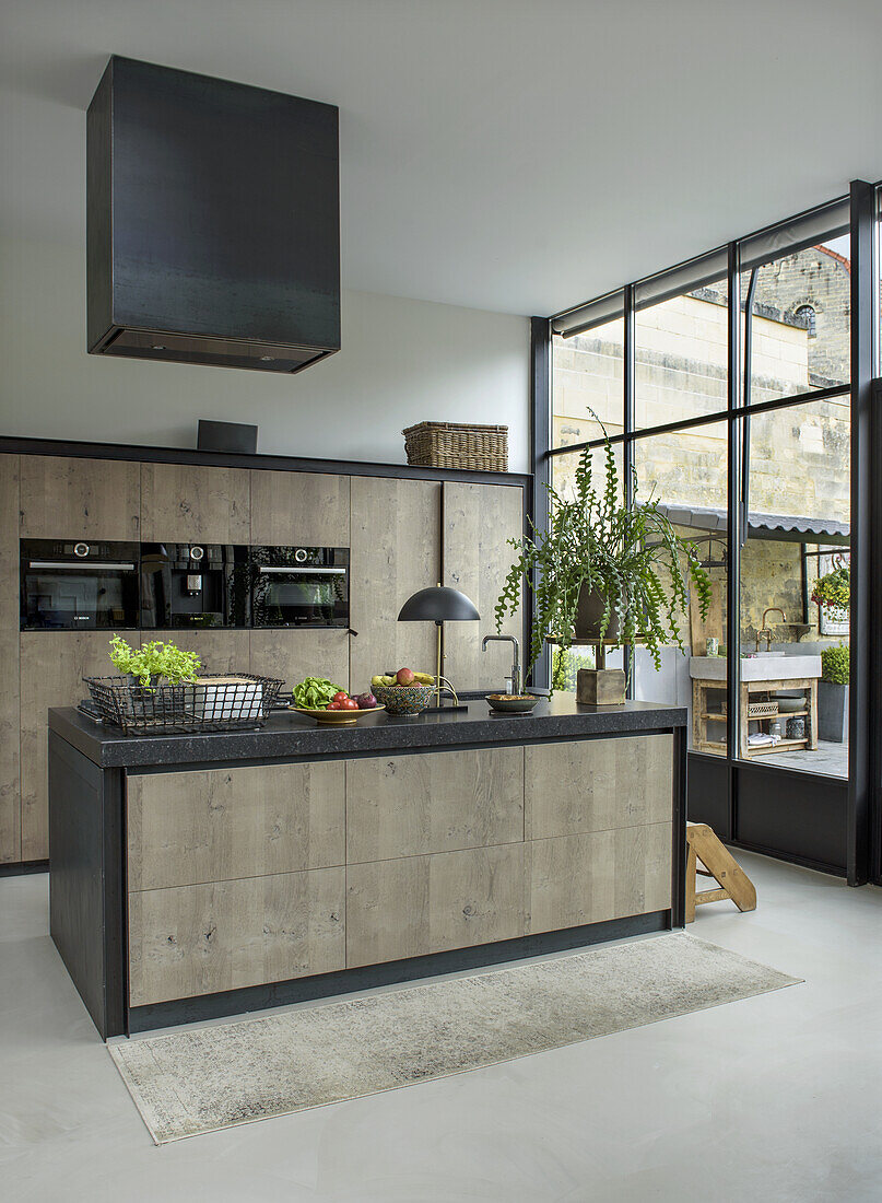 Modern kitchen with large window front, kitchen island and wooden elements