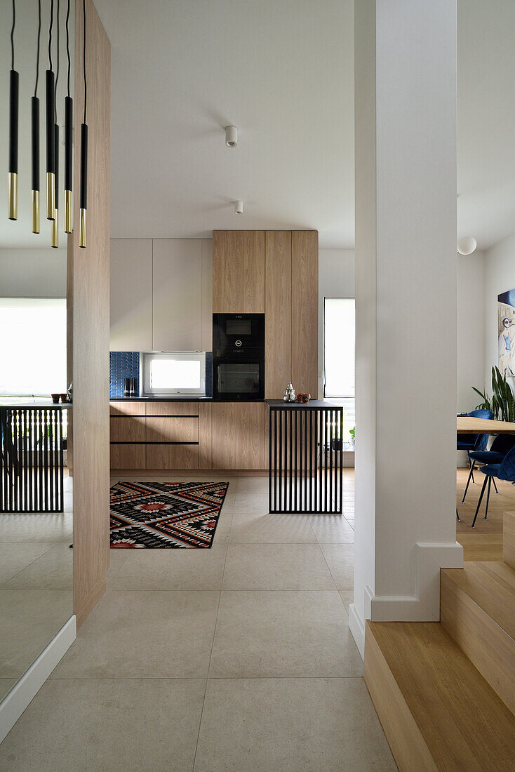 Modern kitchen with wooden elements, pendant light and ethno carpet