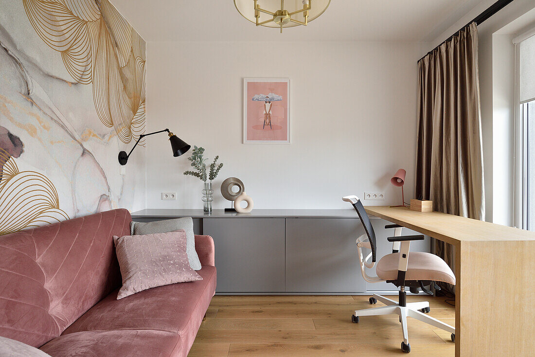 Modern study with desk, pink velvet sofa and floral wallpaper