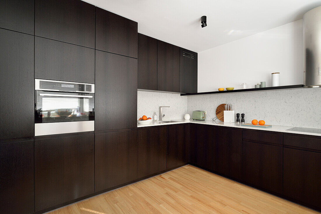 Modern kitchen with dark brown cupboards and wooden floor