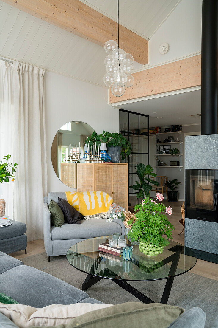 Modern living room with glass coffee table, armchair and fireplace