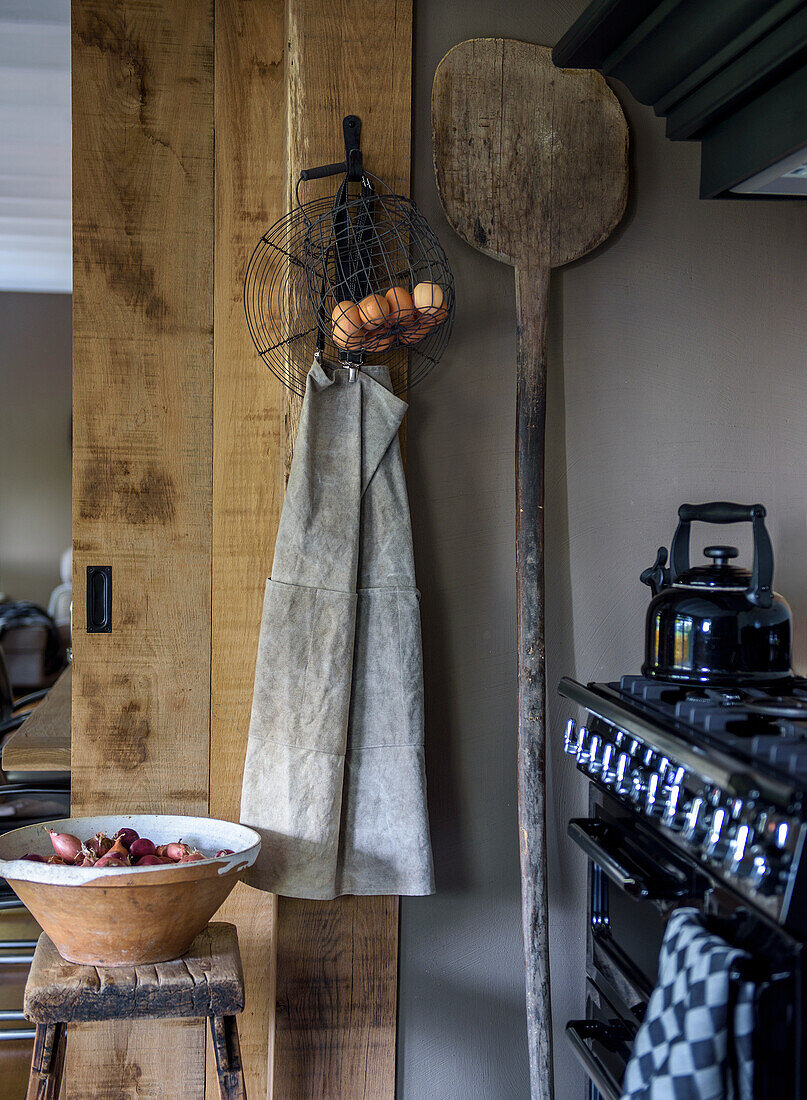 Kitchen corner with gas hob, wooden stool and black kettle