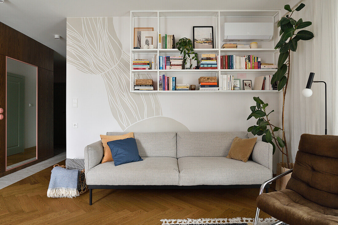 Modern living room with grey sofa, wall shelf and houseplant