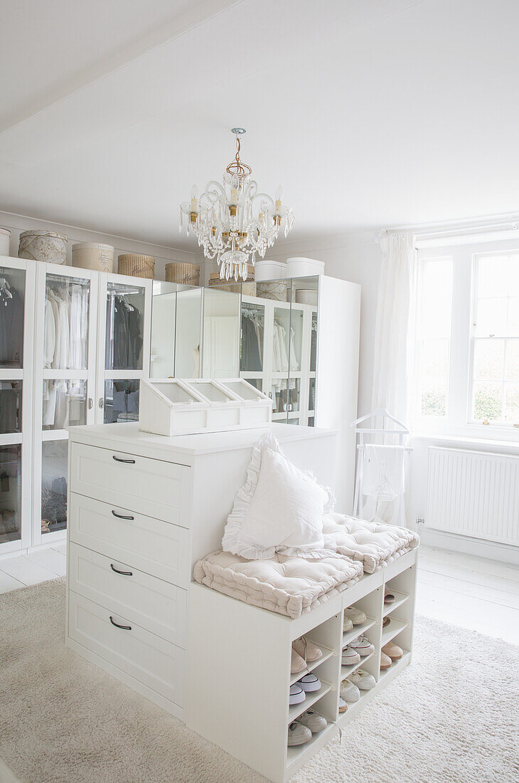 Bright dressing room with chandelier, mirror and shoe racks