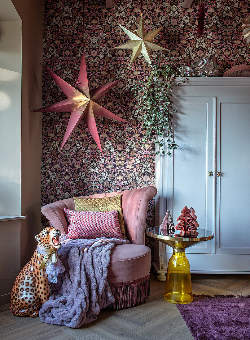 Patterned wallpaper in living room with pink velvet armchair and yellow side table