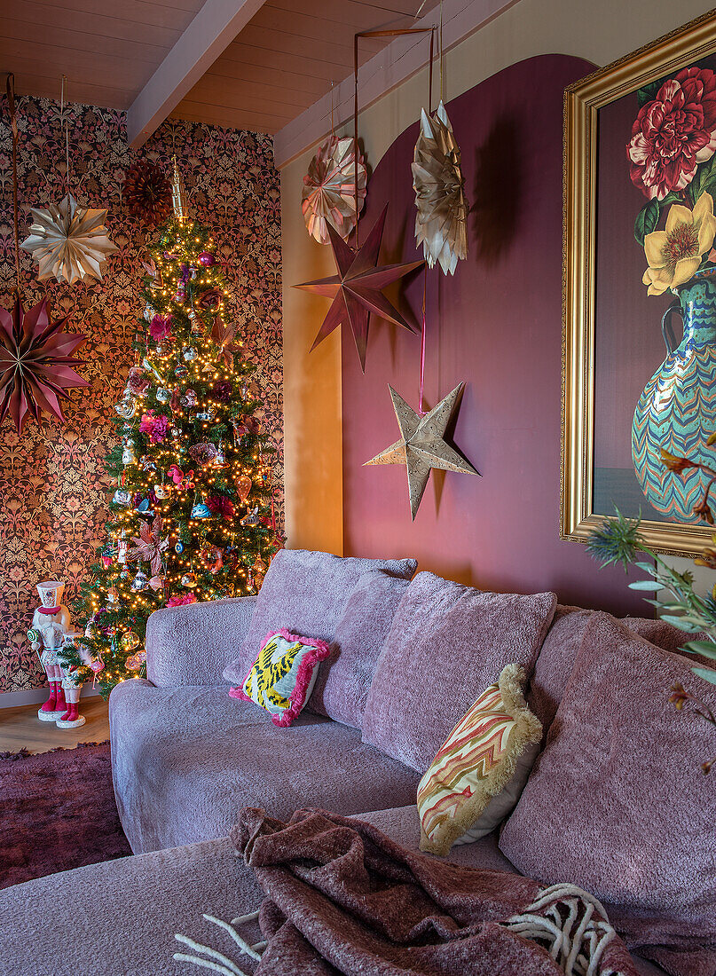 Weihnachtlich dekoriertes Wohnzimmer mit geschmücktem Baum und Sternen