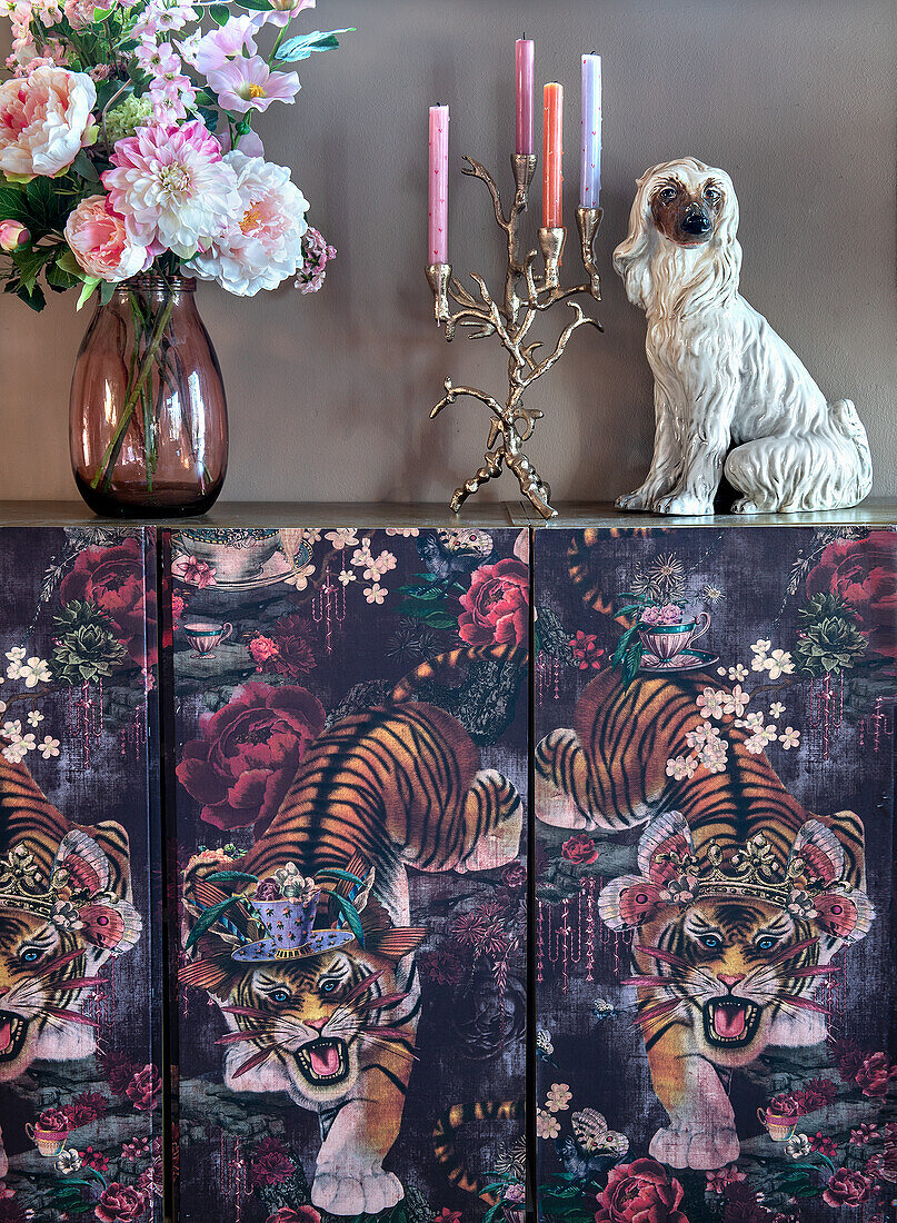 Sideboard im Tiger-Design, Blumenstrauß und Kerzenständer