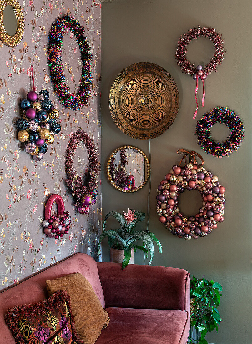 Living room wall decorated for Christmas with wreaths and mirrors