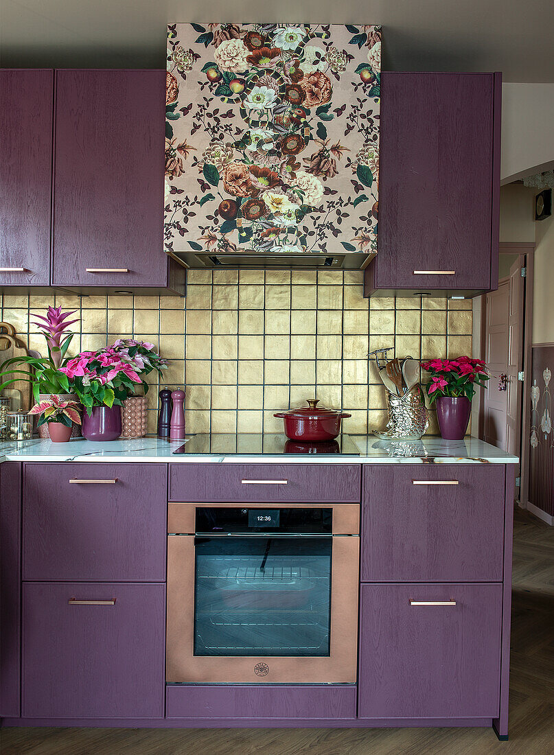 Modern kitchen with purple cabinets and floral patterned extractor hood