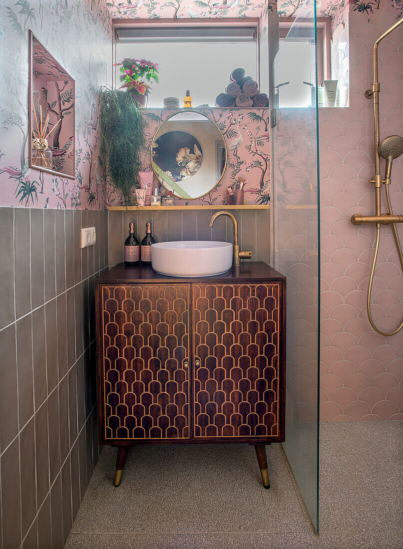 Washbasin with golden fittings on washstand, floor-to-ceiling shower with glass partition wall