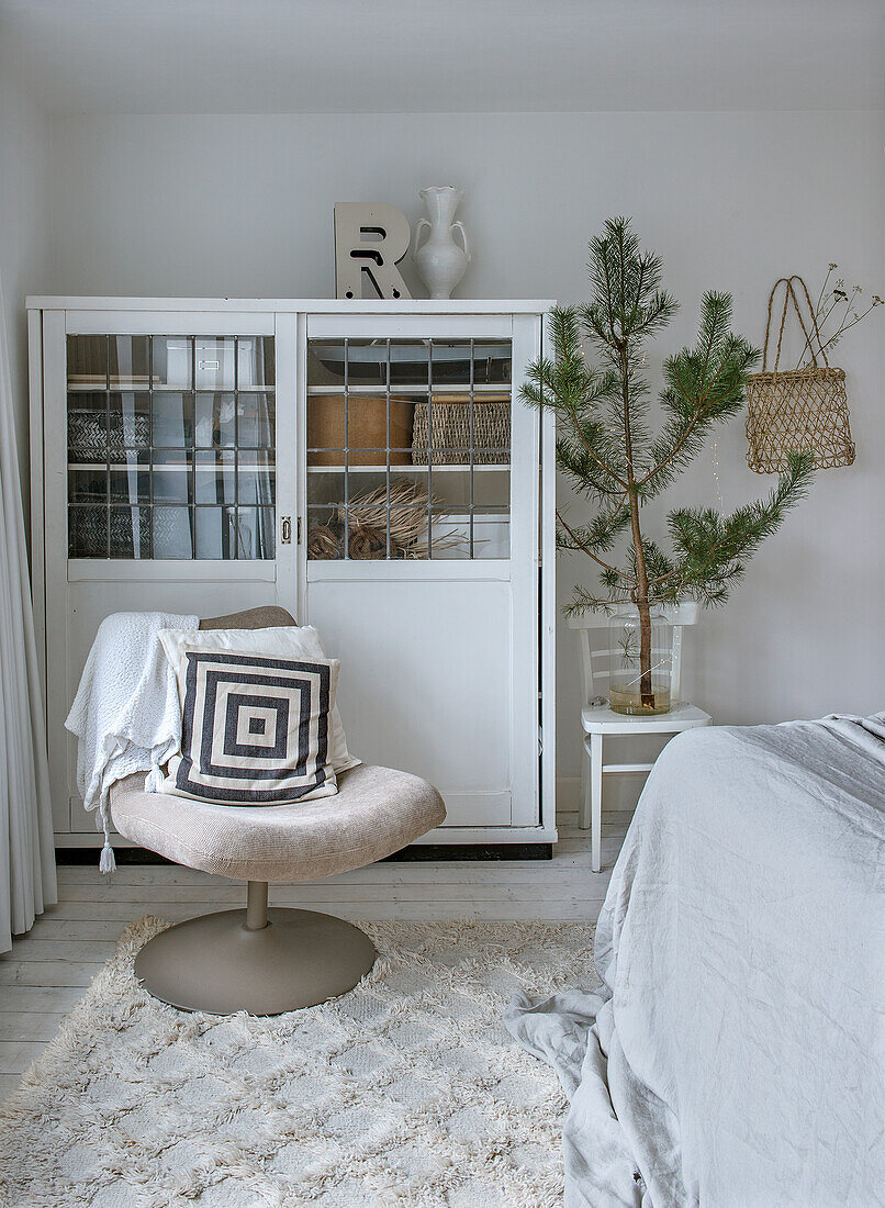 Bedroom with large branch, vintage cupboard and chair