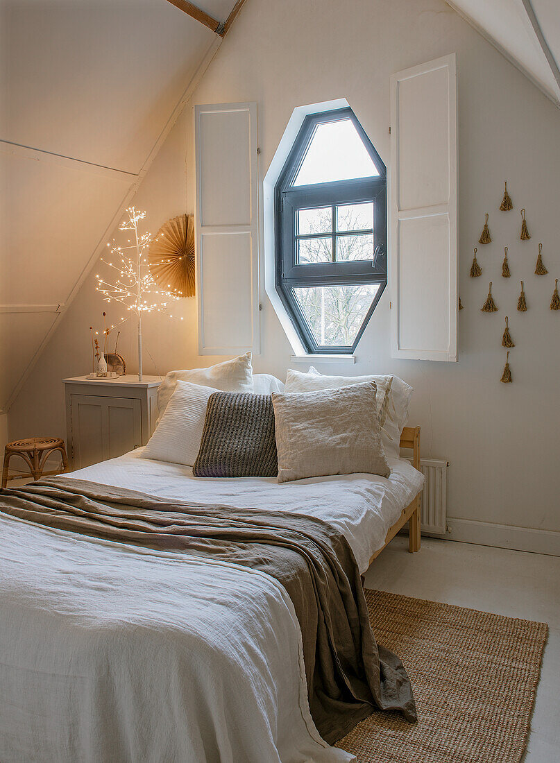 Country-style bedroom with octagonal window, bed and decorations