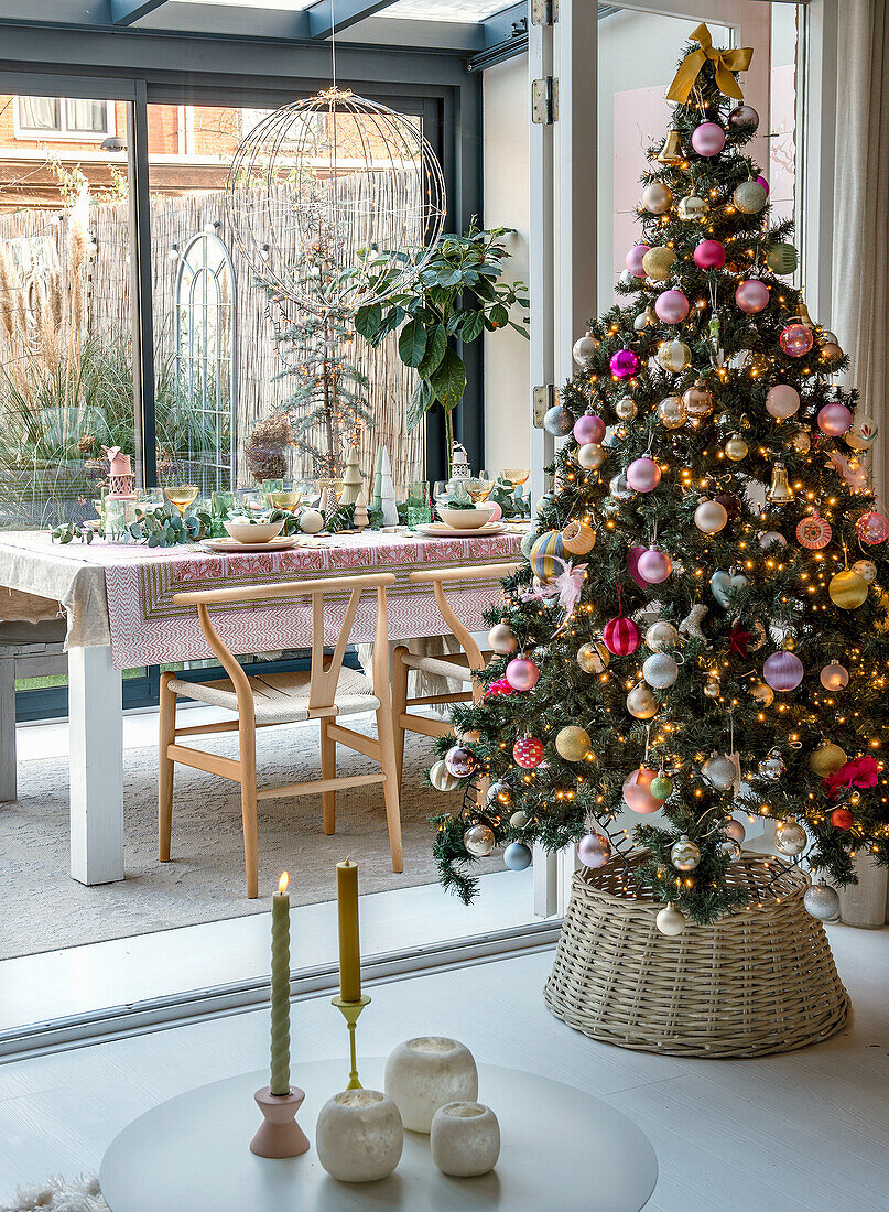 Blick auf geschmückten Weihnachtsbaum und festlich gedeckten Tisch im Wintergarten