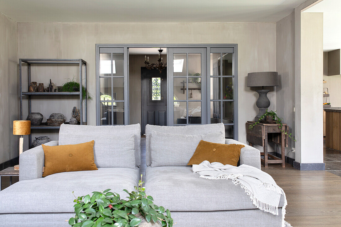 Bright living room with grey sofa and glass doors in the background