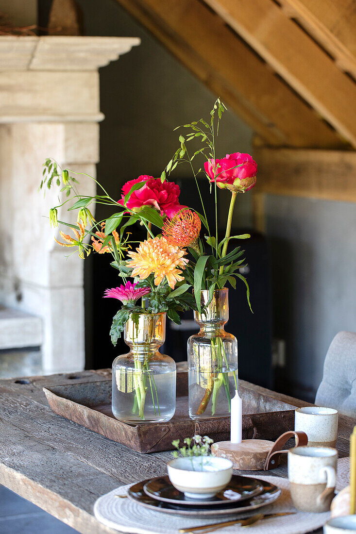 Flower arrangement with dahlias and peonies on a country-style wooden table