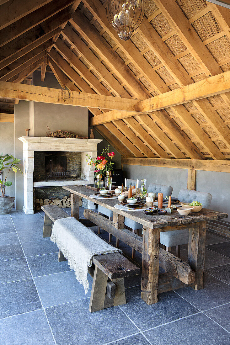 Set table in an open dining area under a wooden roof