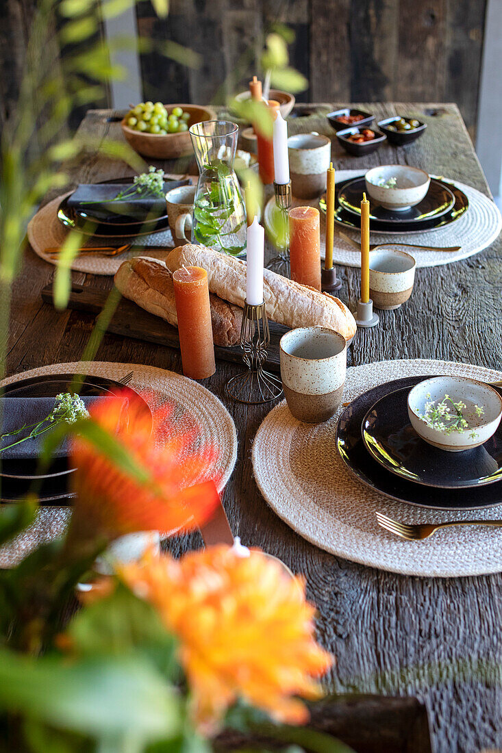 Autumnal table setting with candles and bread on a rustic wooden table