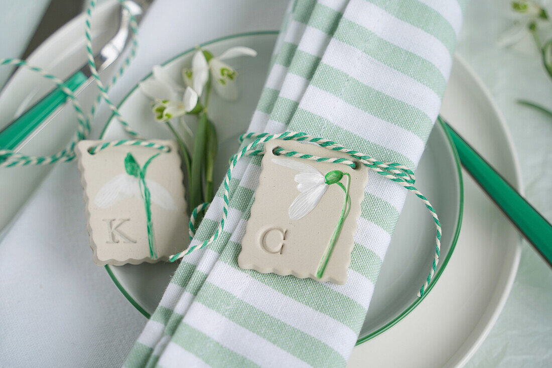 Table decoration made of green and white striped cloth napkin and DIY pendant