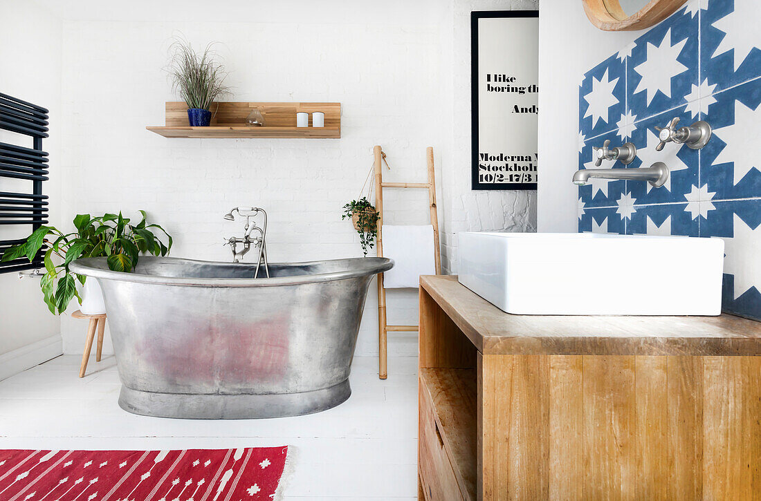 Modern bathroom with freestanding metal bathtub and blue and white patterned tiles