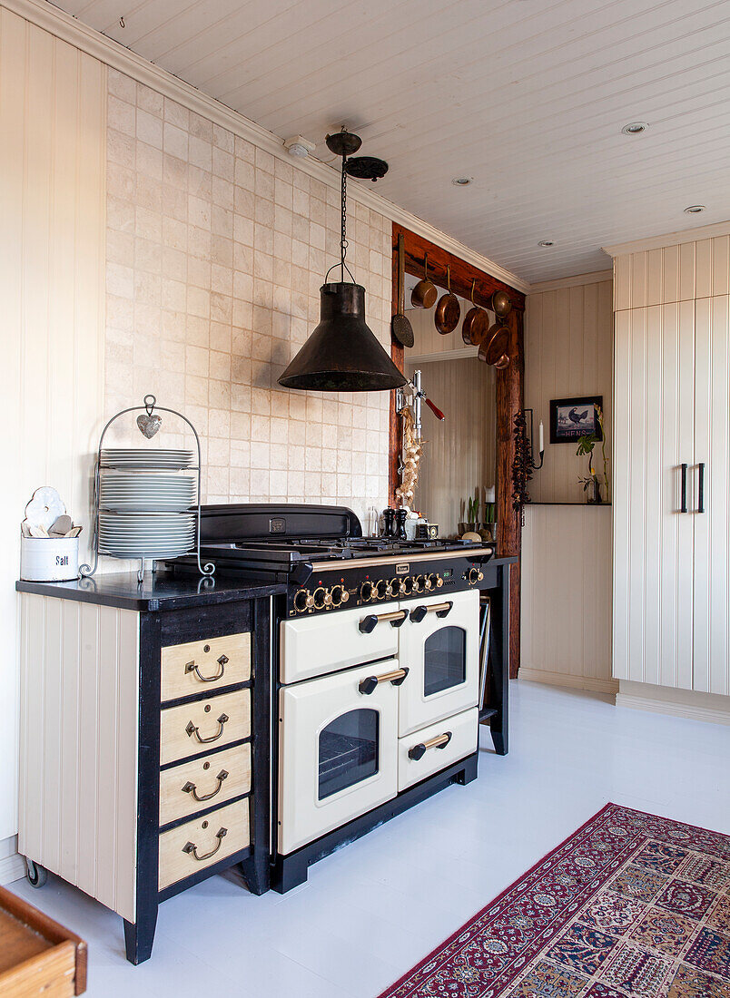 Country-style kitchen with antique stove and black extractor hood