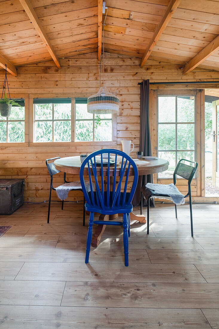 Dining area in a wooden hut with a view of the countryside