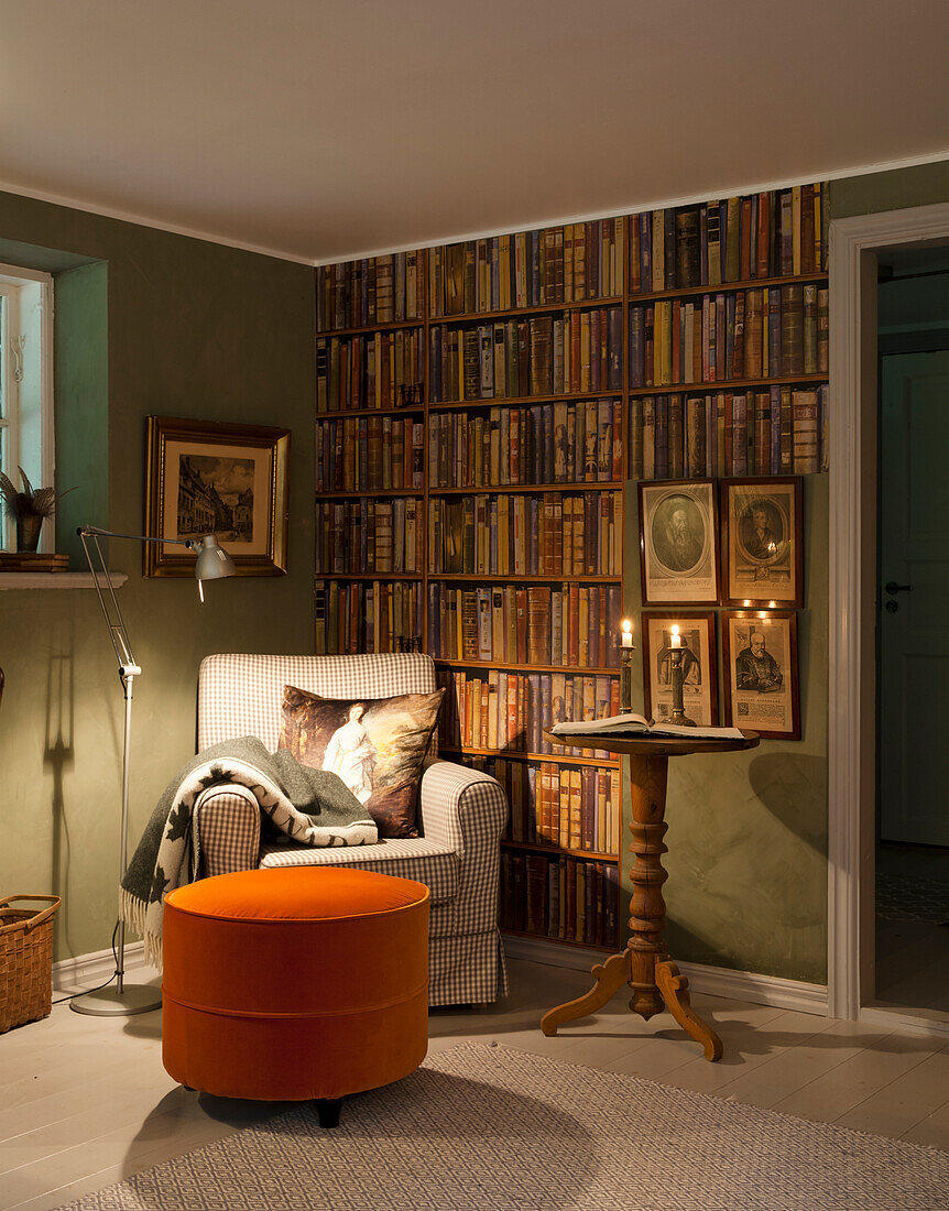 Cozy reading corner with armchair and bookshelf wallpaper