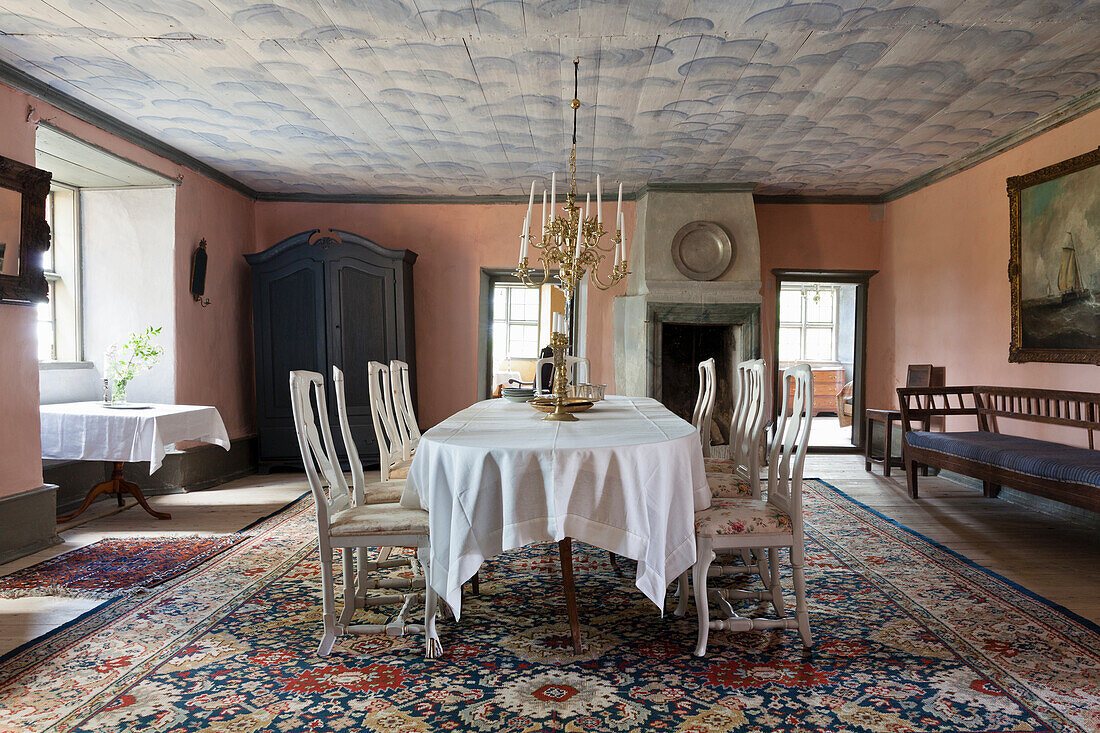 Historic dining room with painted ceiling, chandelier and antique carpet