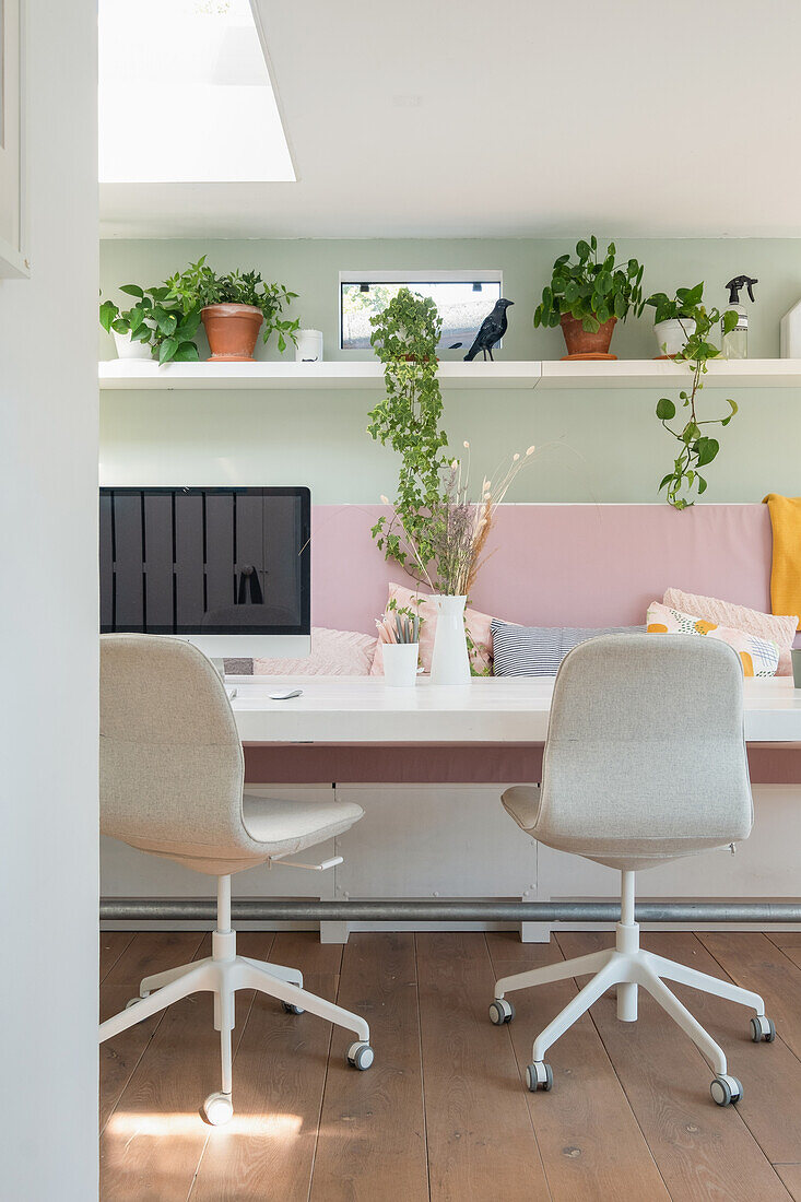 Modern home office with white desk and houseplants on a shelf