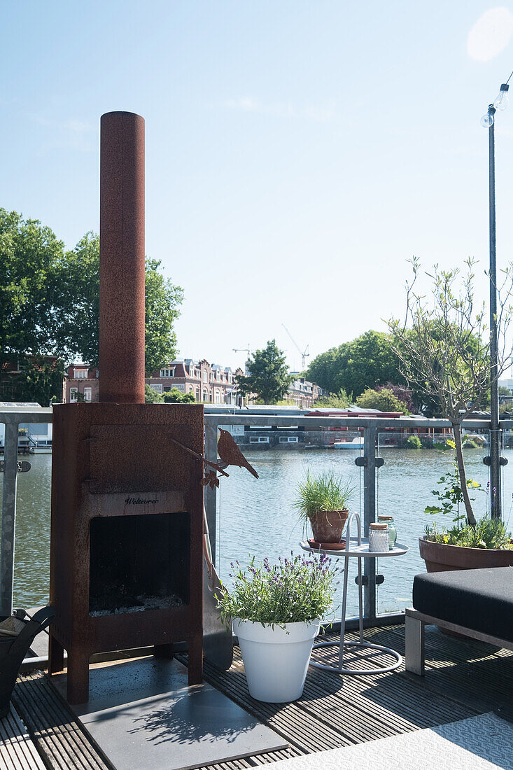 Terrace with river view and outdoor oven surrounded by plants