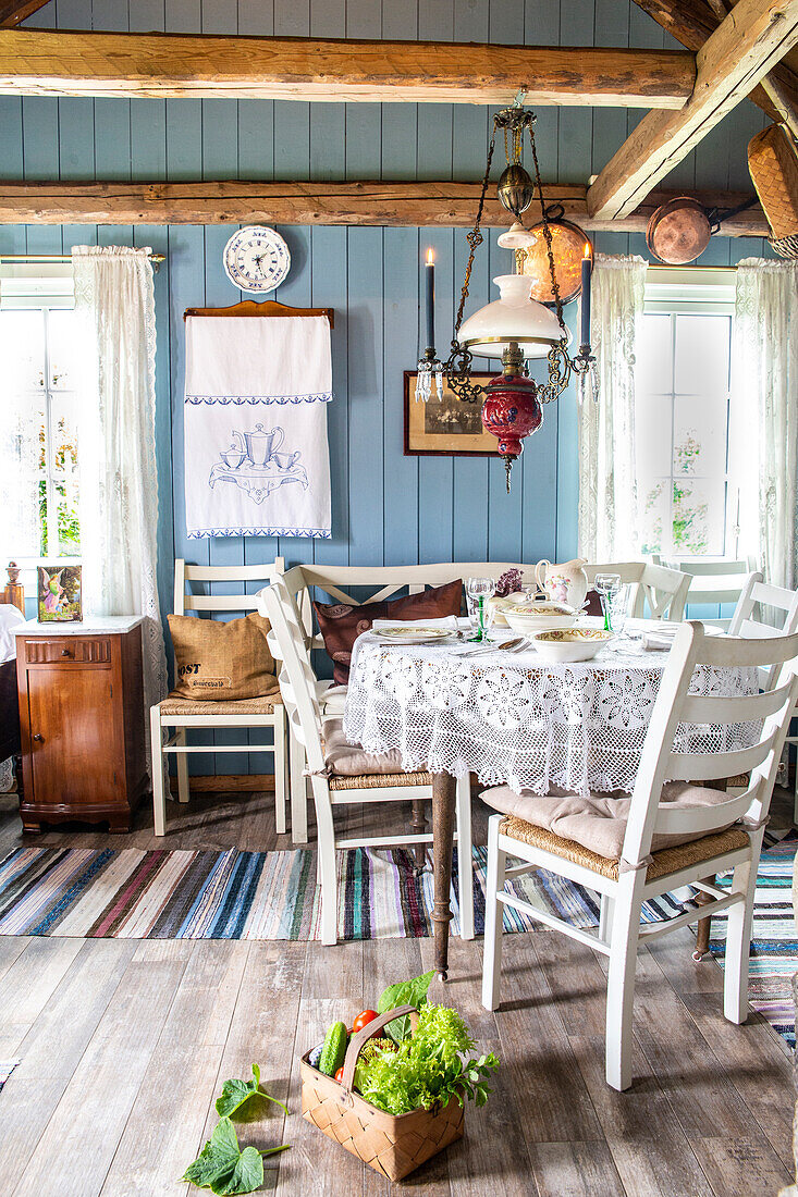 Dining area with lace tablecloth and farmhouse decor in rustic interior