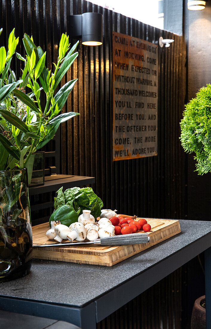 Modern outdoor kitchen with fresh vegetables and plants