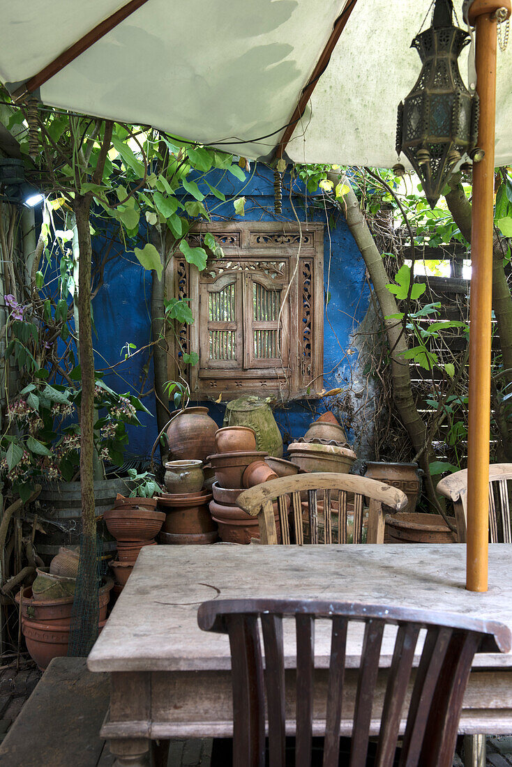 Rustic seating area with wooden table and blue wall in the garden