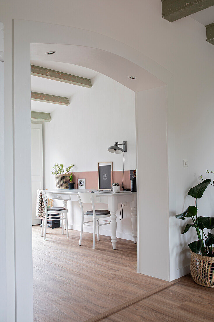 Simple workspace with white furniture and wooden floor in a light-coloured flat