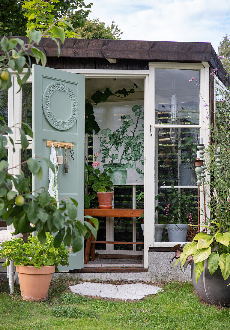 Blick auf Gartenhaus mit offener Tür