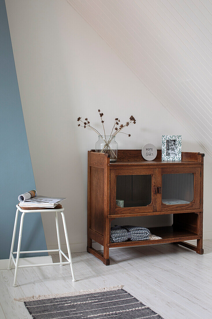 Wooden display cabinet with dried flowers and decoration under sloping roof, white-blue colour scheme