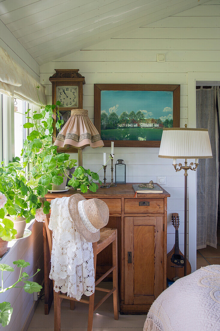 Rustikaler Arbeitsbereich mit antikem Schreibtisch und Grünpflanzen am Fenster