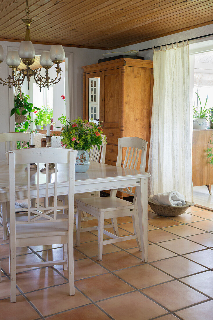 Country-style dining area with wooden furniture and terracotta flooring