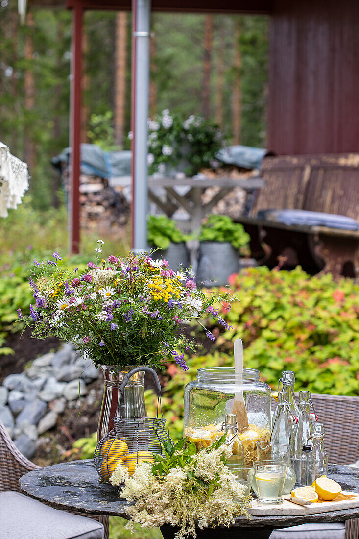 Outdoor patio table with fresh summer flowers and drinks