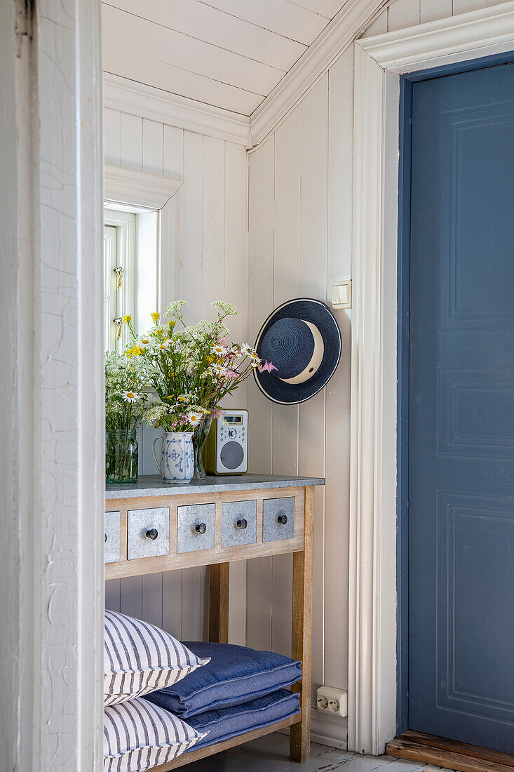 Narrow entrance area with vintage-style console and blue door