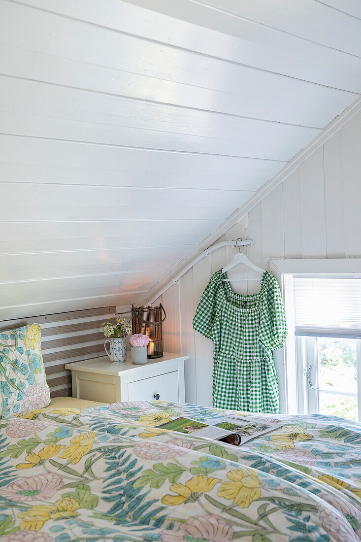 Landhausstil-Schlafzimmer mit Holzvertäfelung und floraler Bettwäsche