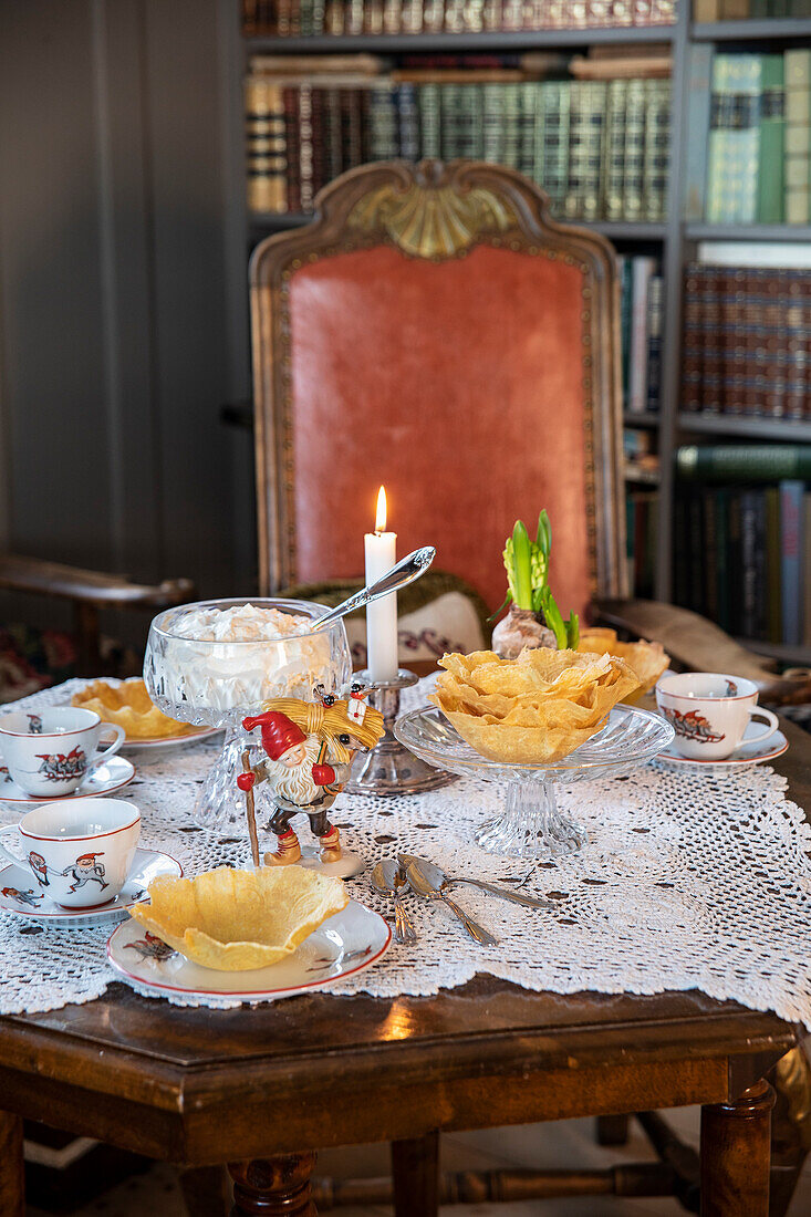 Eleganter Nachmittagstee mit Gebäck und Kerzen auf altem Holztisch