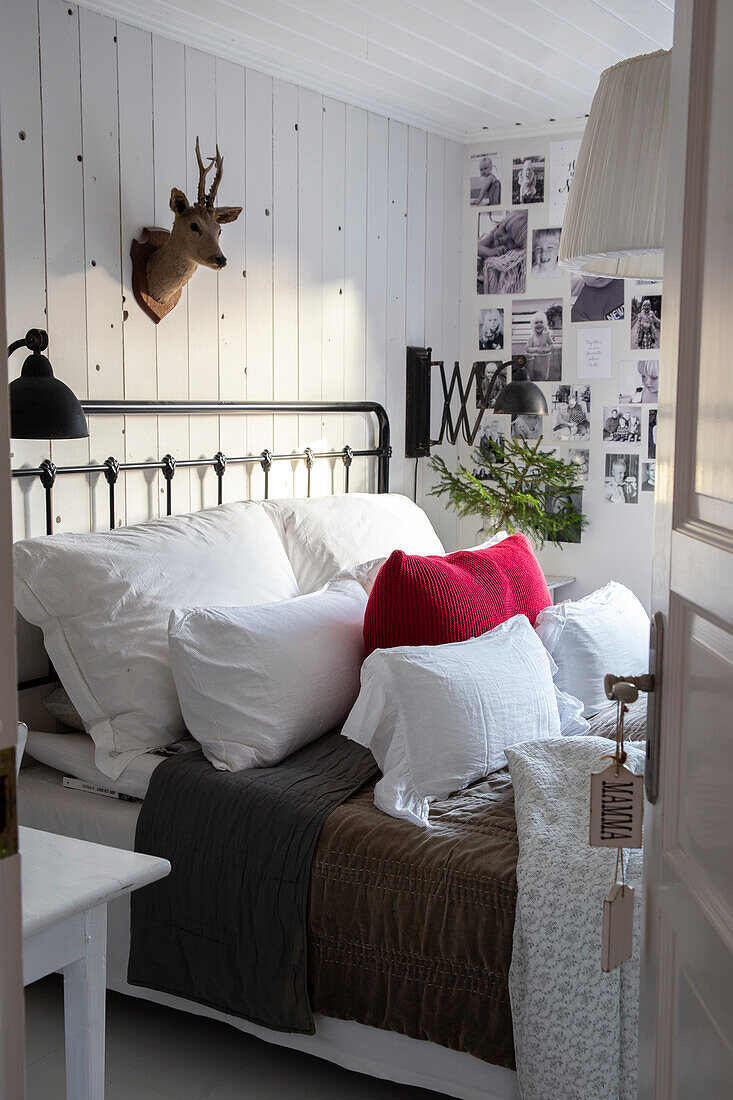 Bedroom with metal bed, photo wall and deer antler decor